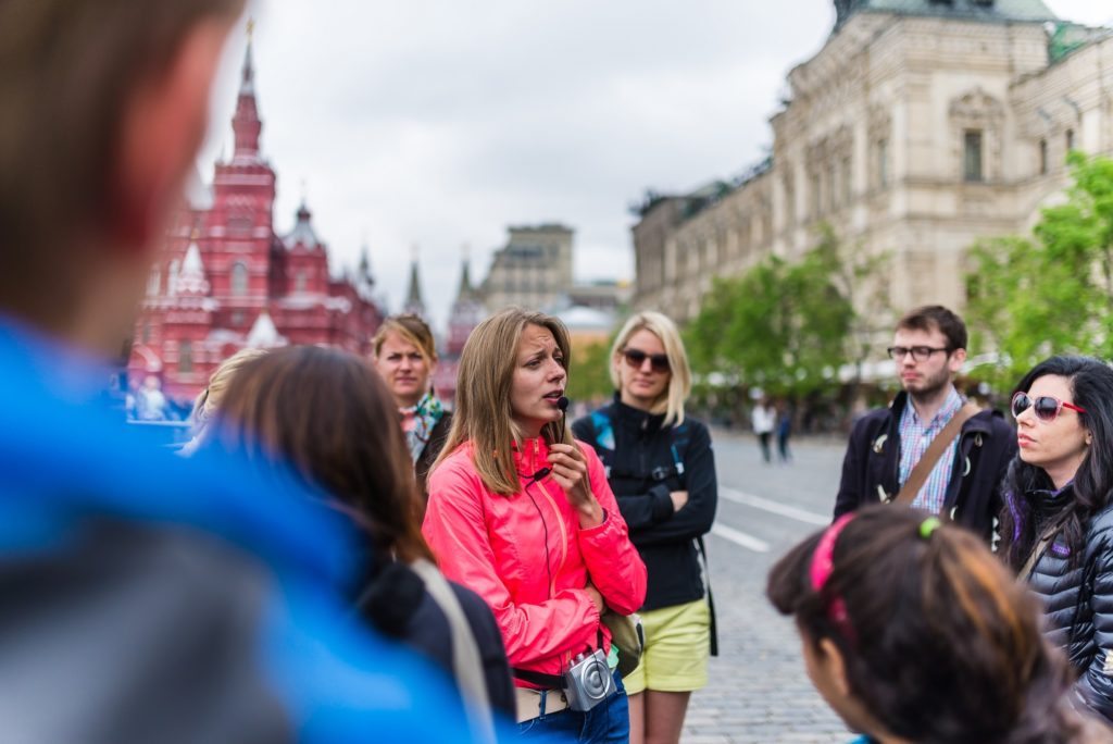 Female tour guide greeting a tour group in Russia for tour guide work experience