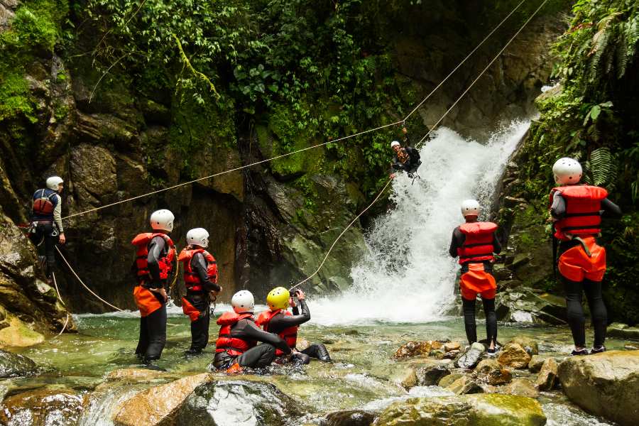 ziplining over a waterfall with a group 