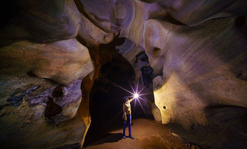 person wearing headlamp while touring a cave